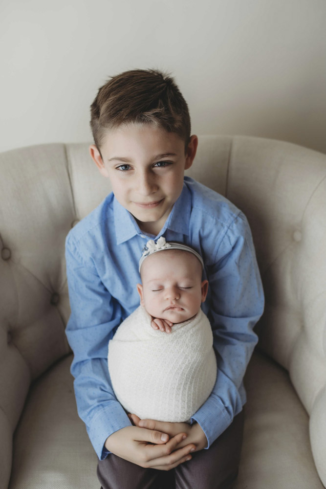 young boy holding his baby sibling