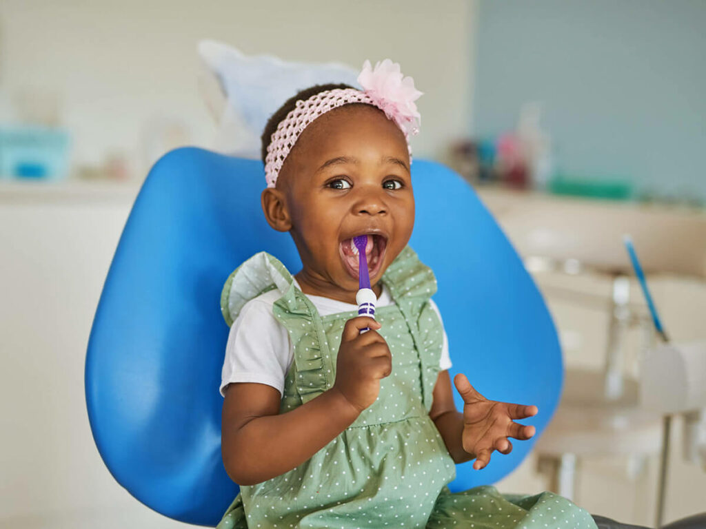 toddler holding a toothbrush in her mouth