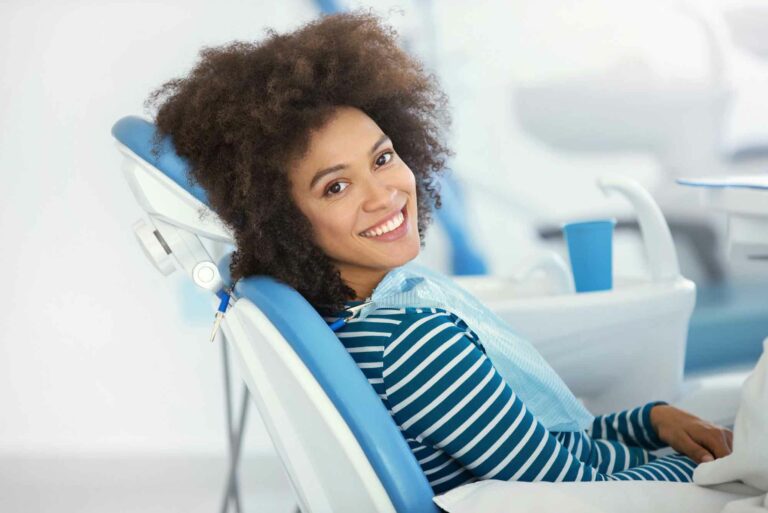 woman sitting at the dentist looking relaxed and smiling