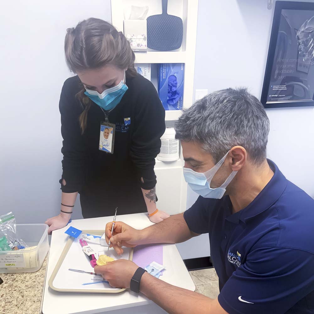 dentist creates a mouth mold while another dentist watches